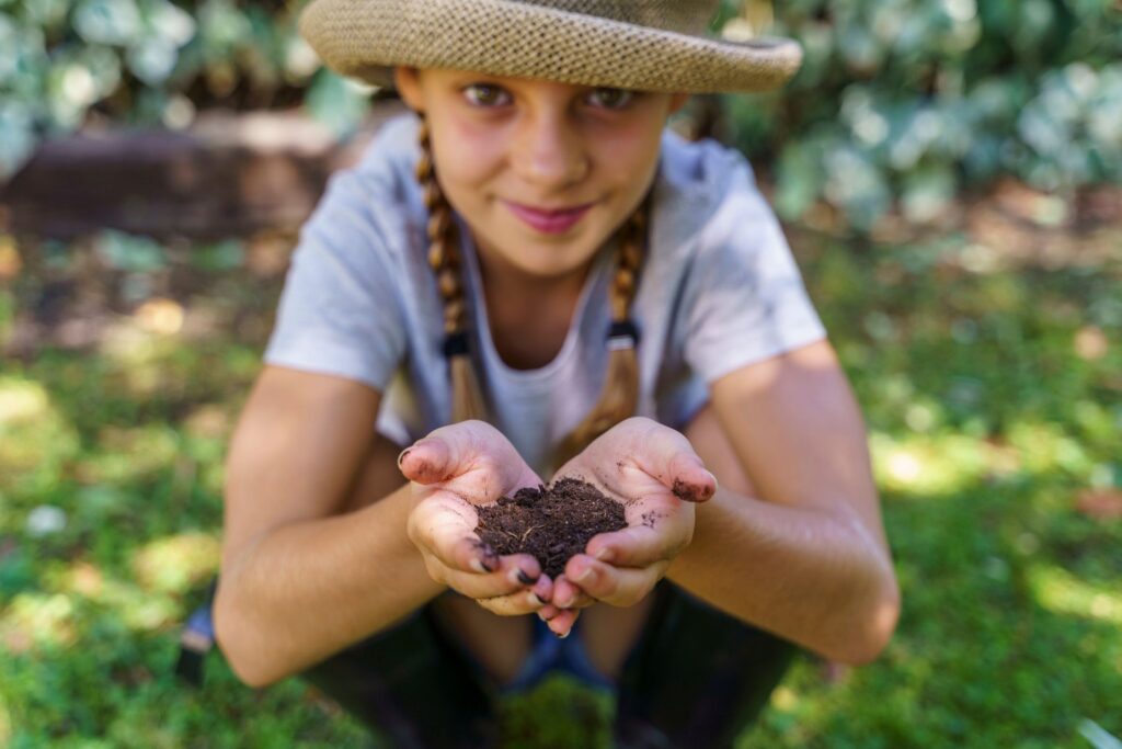 A young girl holding completed compost