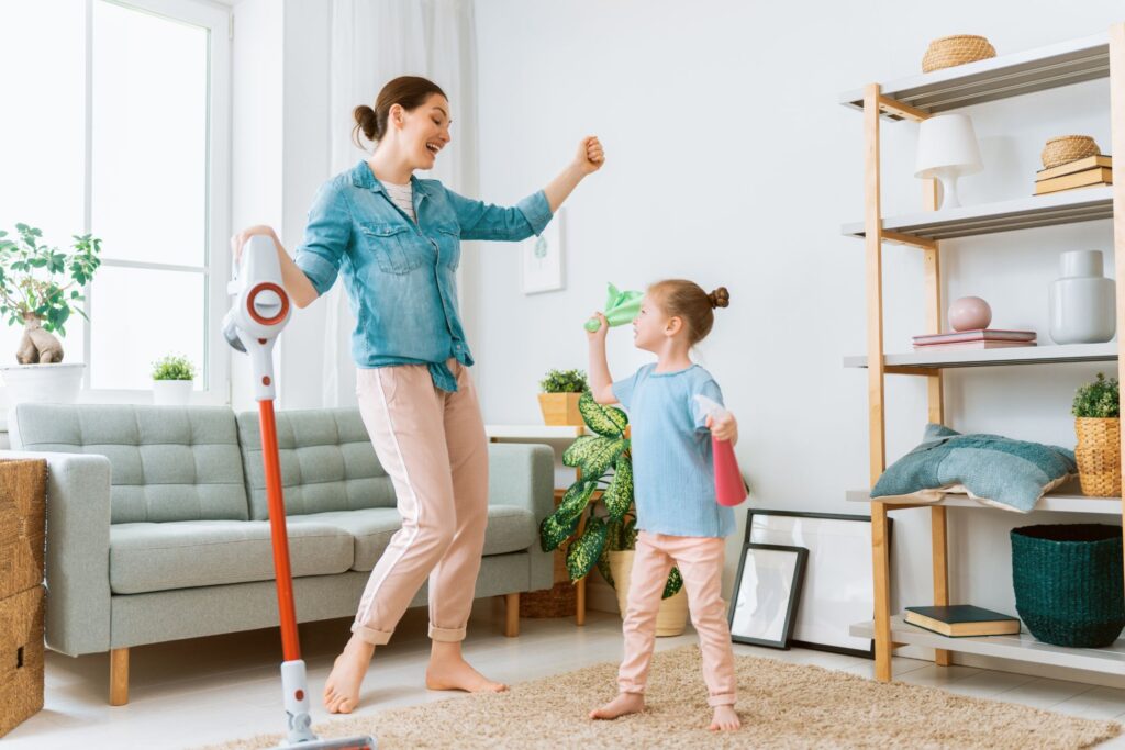 image of woman and child dancing in the living room while cleaning