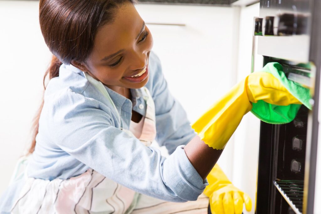 image of a woman cleaning the oven