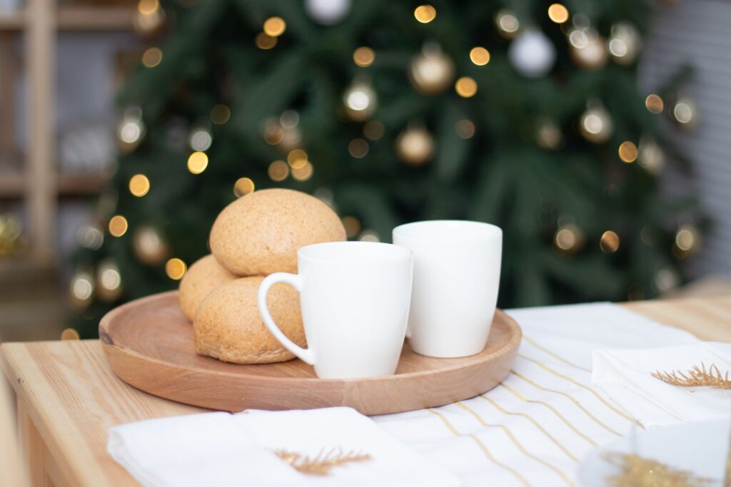 image of coffee cups and dinner rolls in front of a Christmas tree