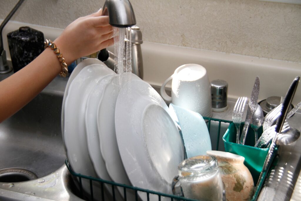 image of someone rinsing dishes