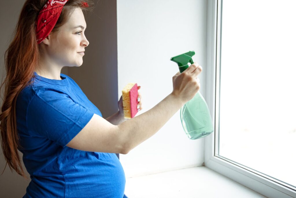 image of pregnant woman cleaning a window