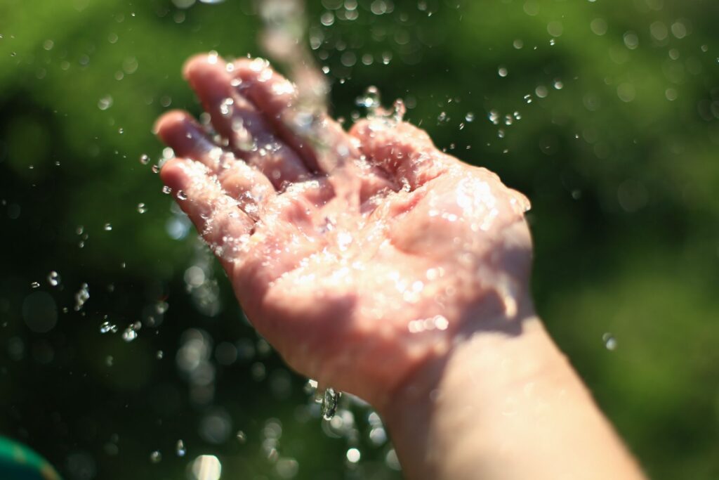 image of hand catching droplets of water