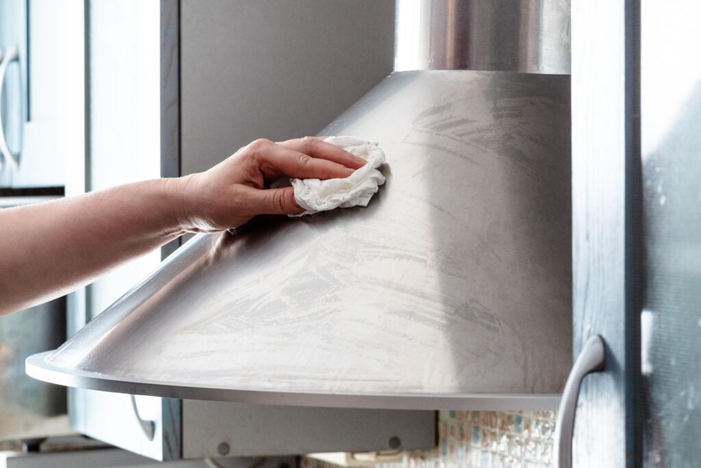 image of someone cleaning a stove hood