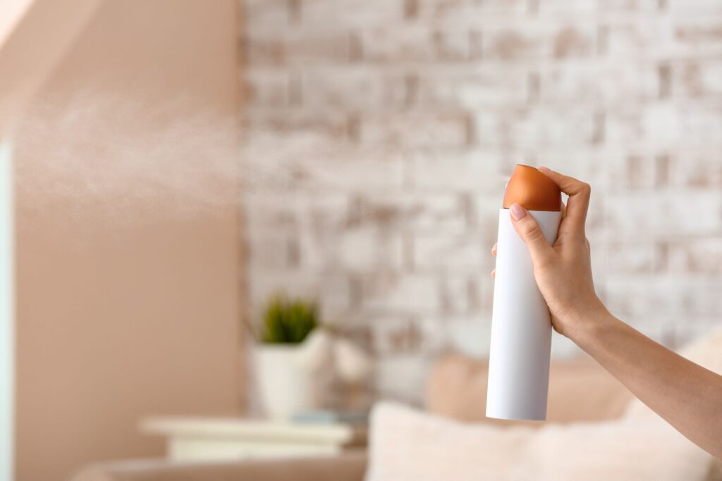 a woman spraying air freshener