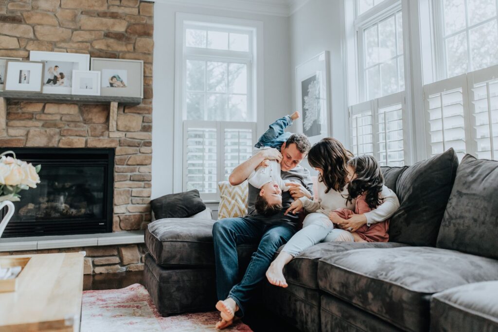 image of a family gathered on a couch in front of a fire place