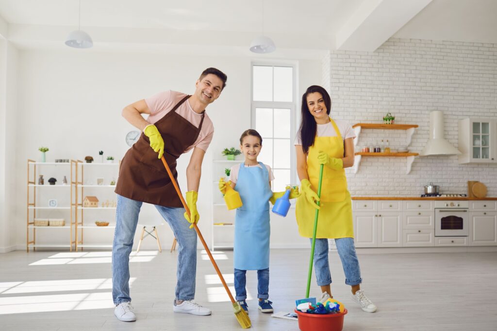 image of a couple with a child armed with cleaning supplies in a sparkling clean kitchen