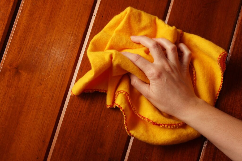 image of someone polishing wood with an orange cloth