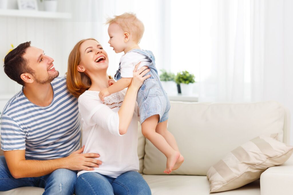 image of a happy couple with a toddler sitting on a couch