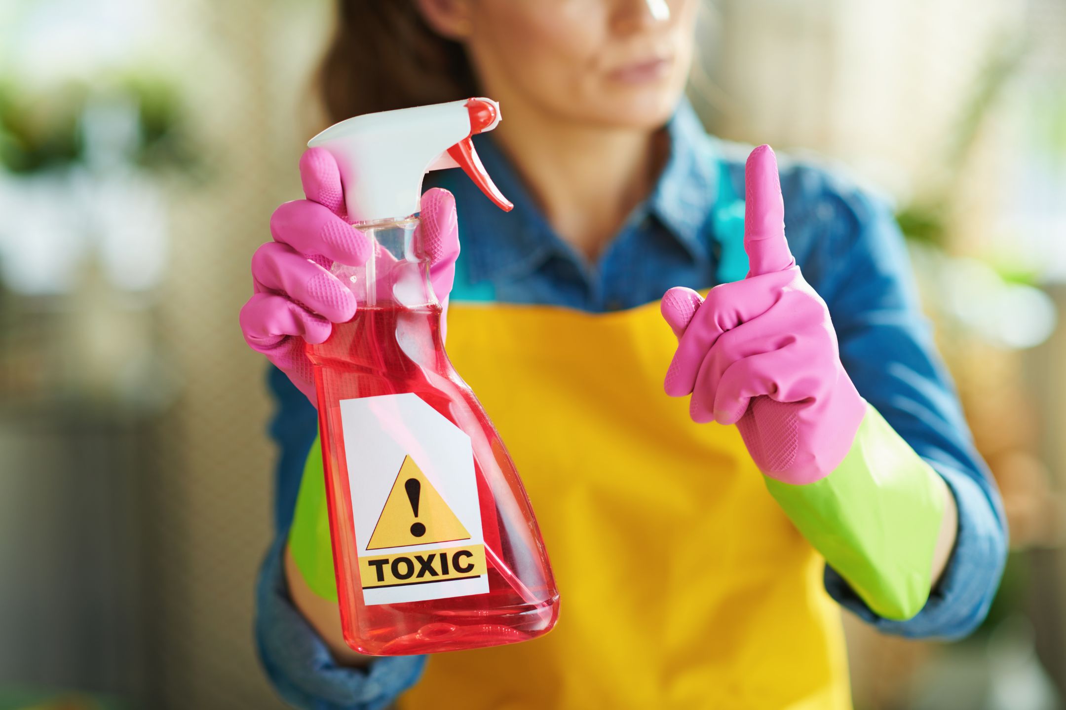 image of a woman holding a poisonous household cleaner