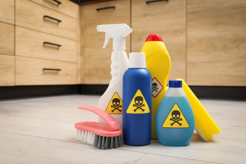 image of toxic cleaners sitting. onthe kitchen floor with skulls and crossbones on their label