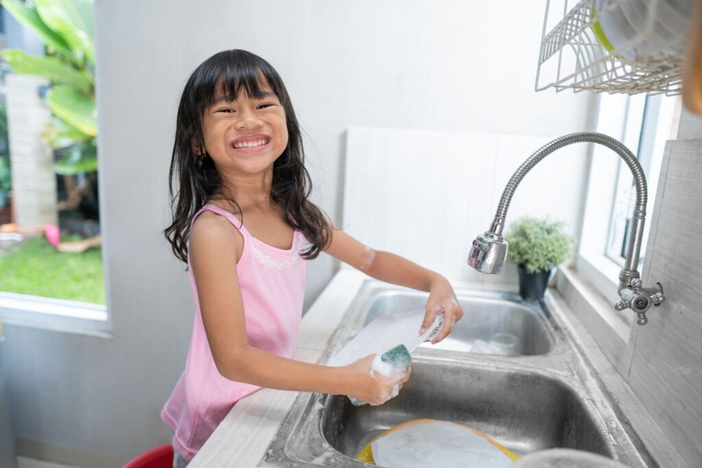 image of a little girl washing dishes