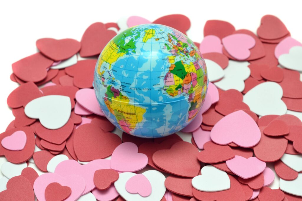 image of a miniture globe on a pile of foam hearts