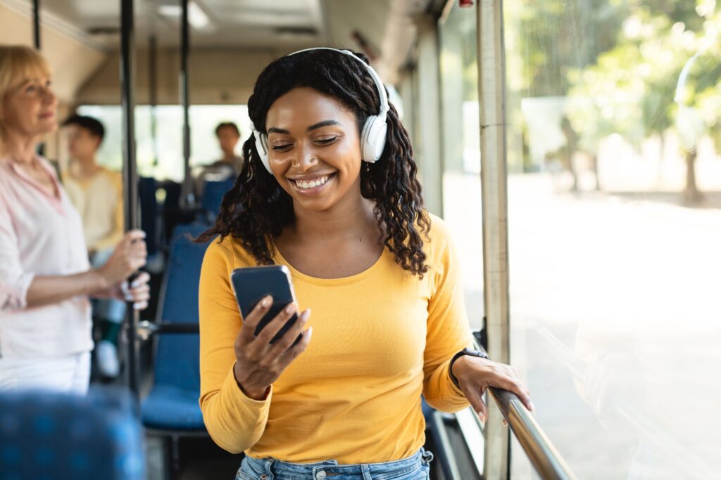 image of a woman smiling at her phone while on the bus