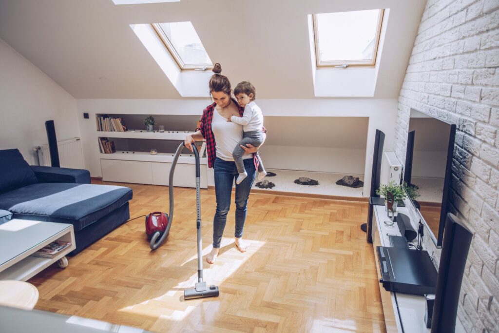 image of mom vacuuming with toddler on hip